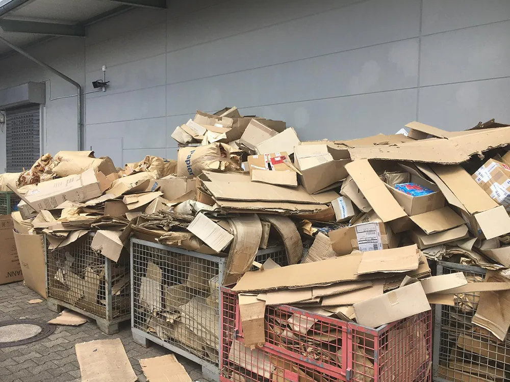 Lose Kartonagen in Gitterboxen vor der Entsorgung